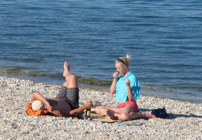 Вода в море пока холодная, но на пляжах уже появились загорающие люди 